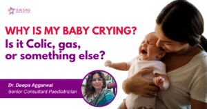 A tired mother holding a crying baby in her arms at home, representing common parenting struggles like colic, gas, or infant discomfort – featured for a pediatric blog by Dr. Deepa Aggarwal.